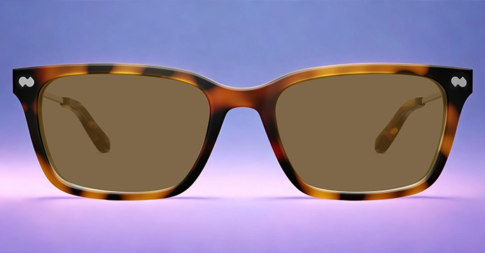 Optician presenting two eyeglass styles to a seated customer at a table